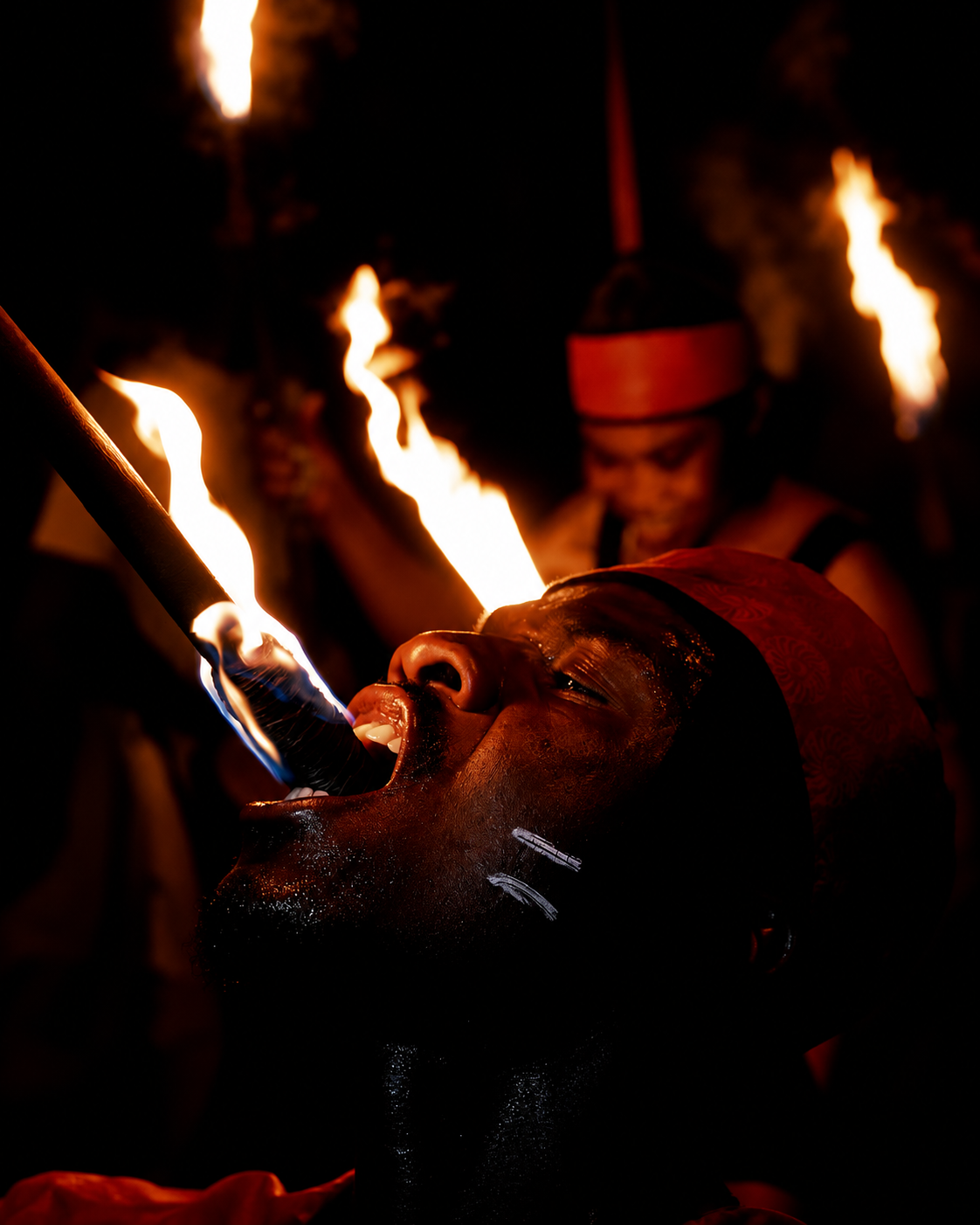 A fire performer in Marrakech at night, flames lit against a dark background